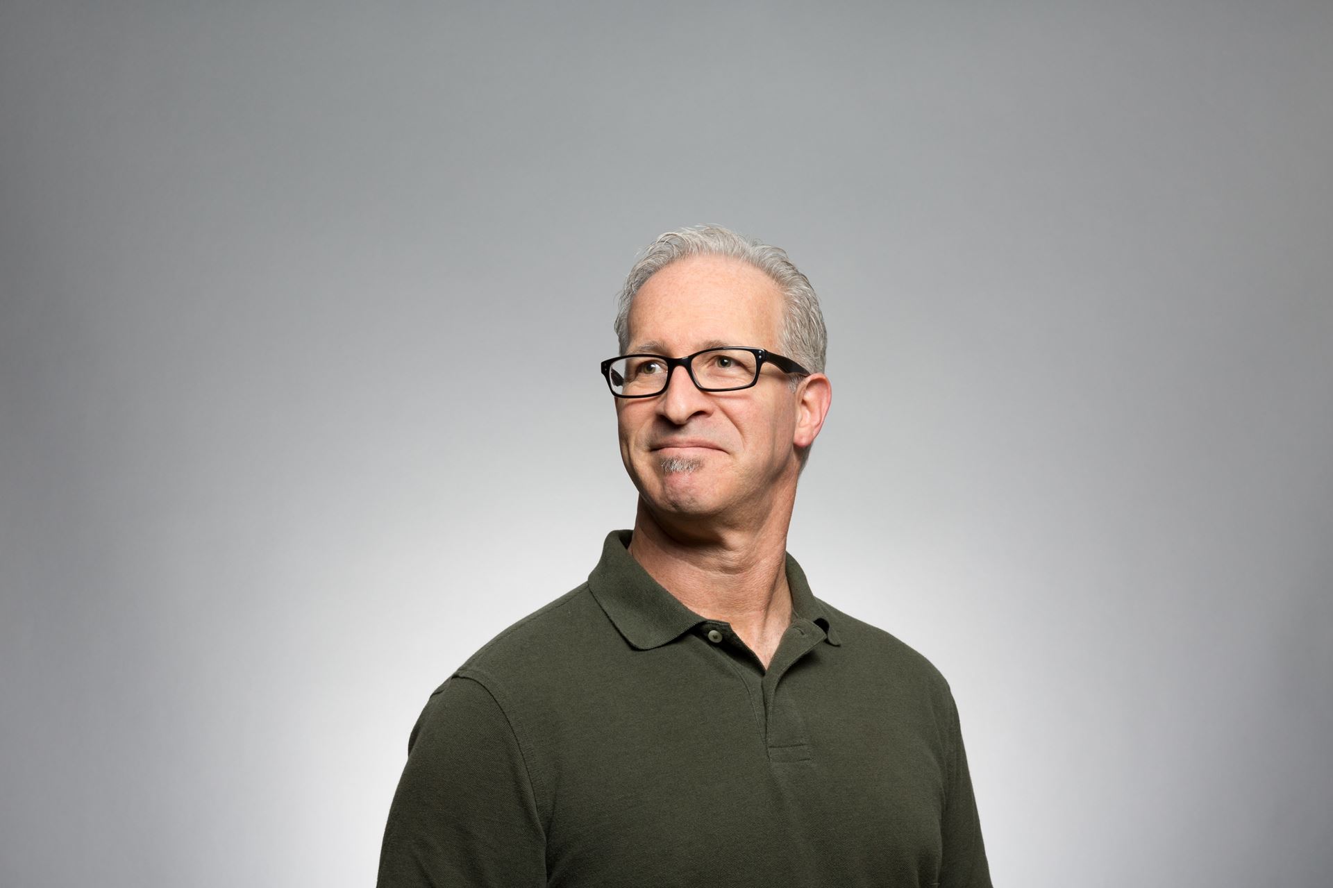 a man wearing glasses and smiling at the camera